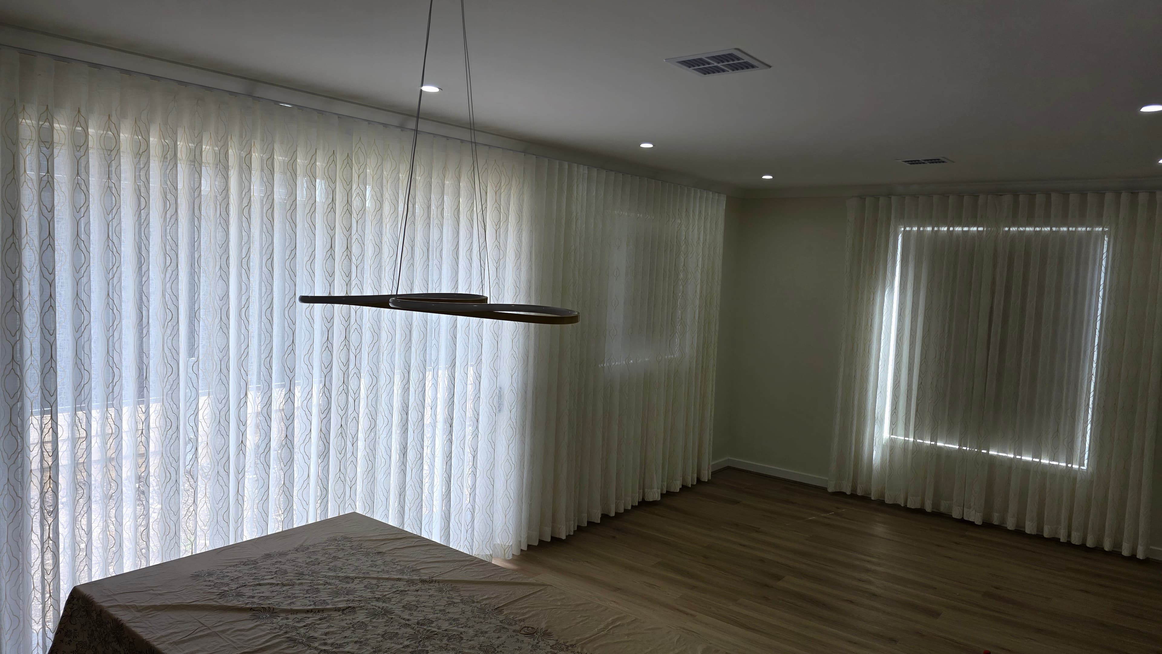 Sheer S-fold curtains spanning full wall of a dining room