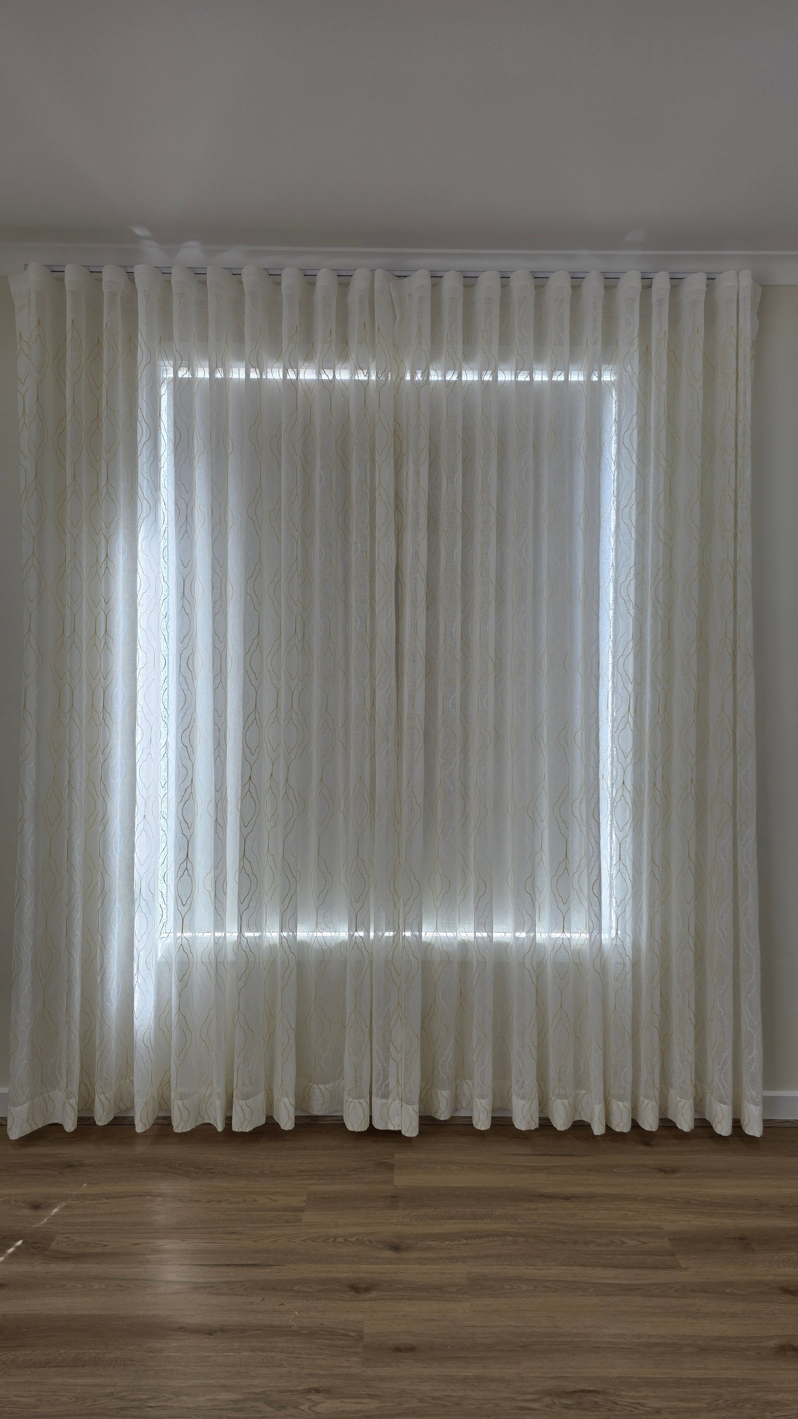 S-fold sheer curtains elegantly dressing a bedroom window