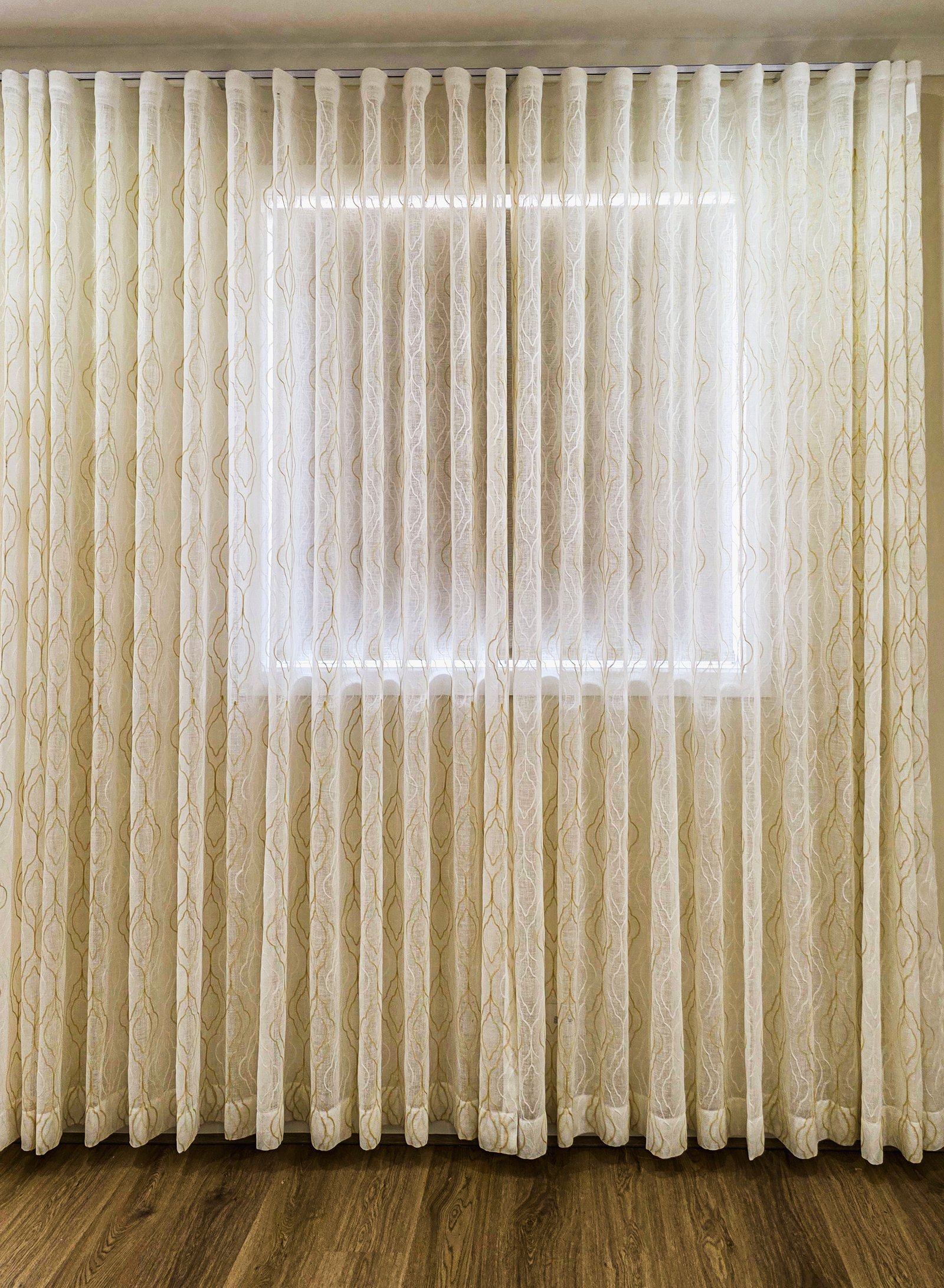 Beautiful S-fold sheer curtains spanning across a wide living area